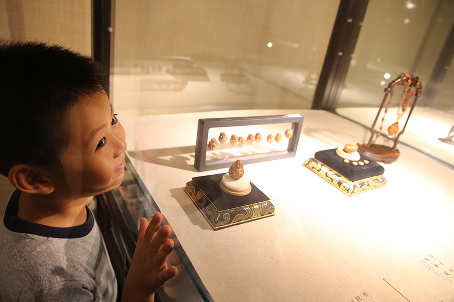 Craftsmanship of fruit pit carving on show in Beijing