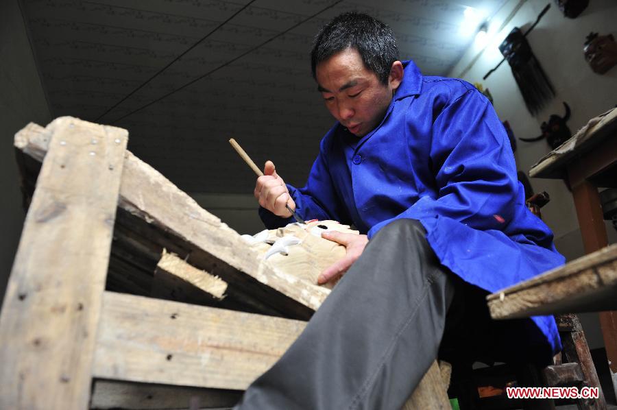 Folk artisan works on Nuo Opera masks