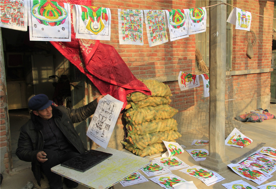 Folk artists create lunar New Year's woodblock paintings in C China