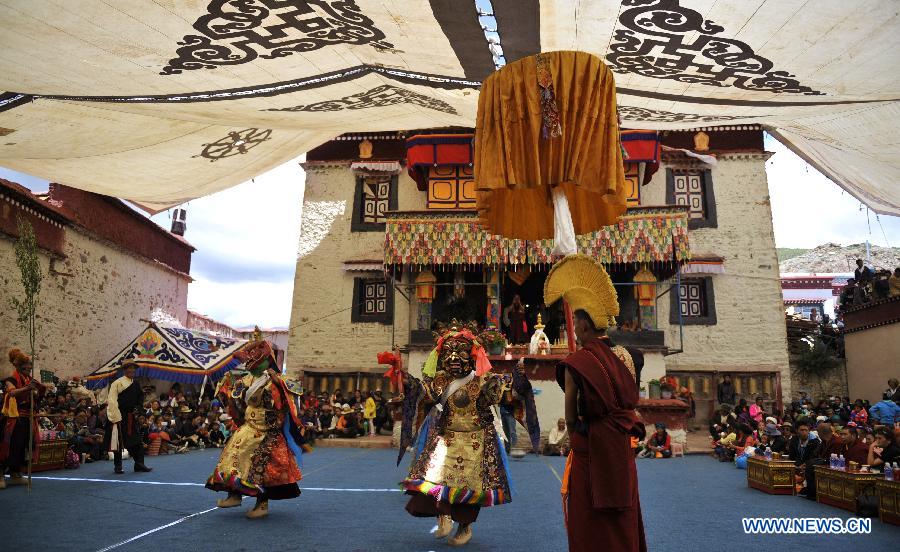 Tibetan Buddhist monks perform cham dance during ritual