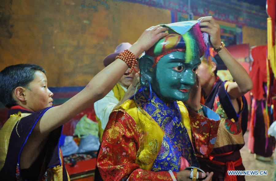 Tibetan Buddhist monks perform cham dance during ritual