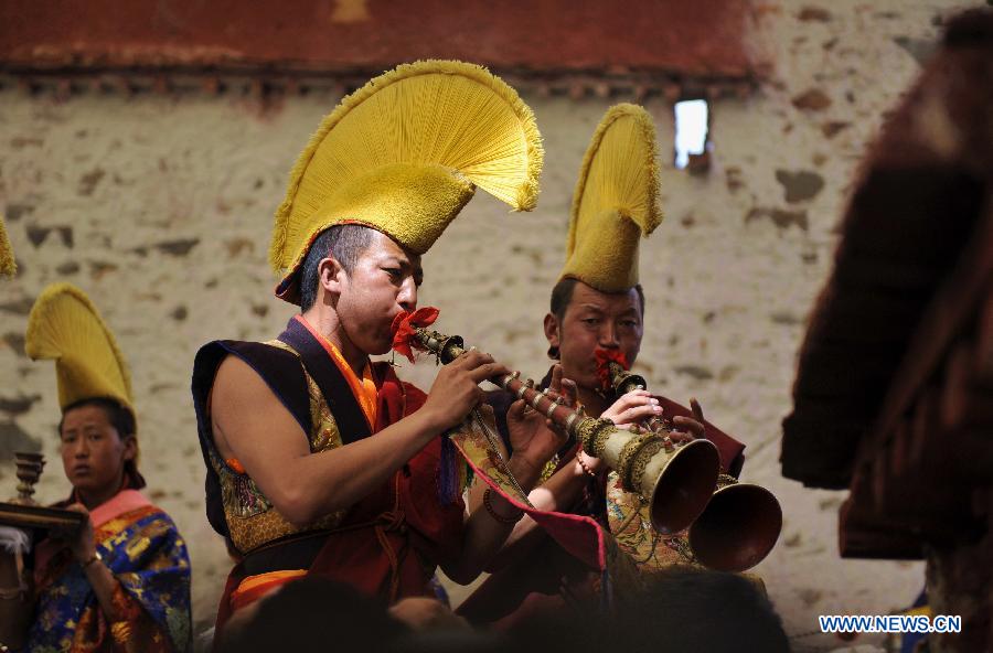 Tibetan Buddhist monks perform cham dance during ritual