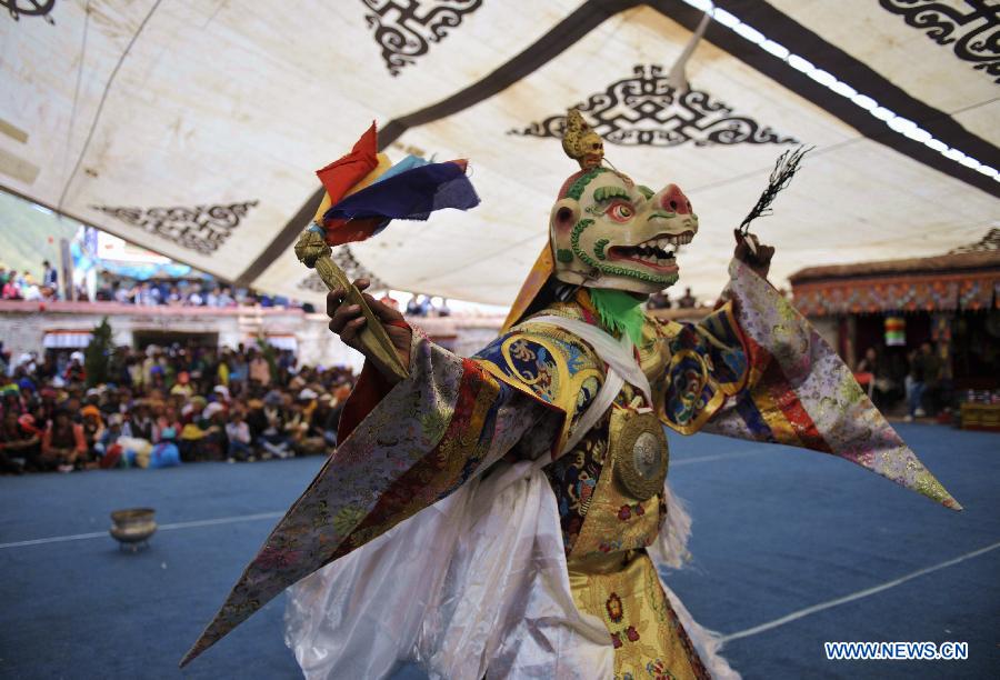 Tibetan Buddhist monks perform cham dance during ritual