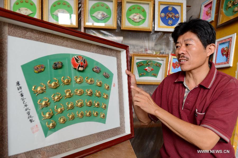 Villager in Heibei province draws paintings on crab shells