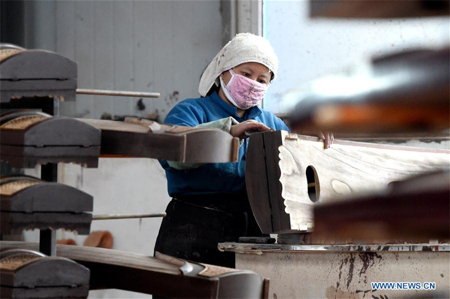 Workers make Chinese traditional music instruments Guzheng in Henan