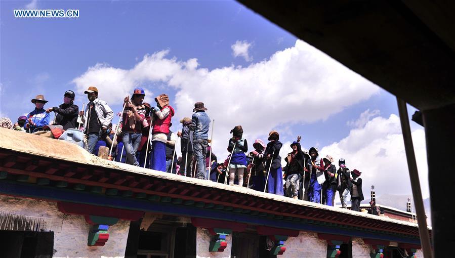 Craftswomen repair roof of Tibet monastery