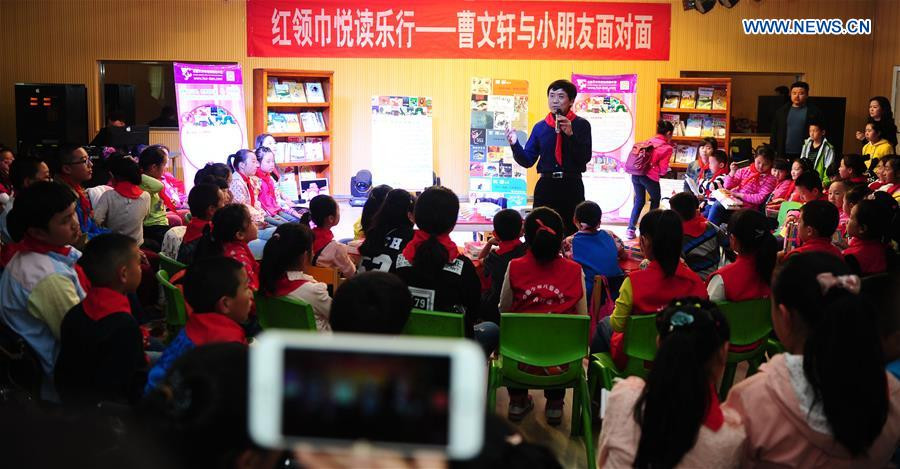 Cao Wenxuan presents books to children, Northwest China's Xinjiang