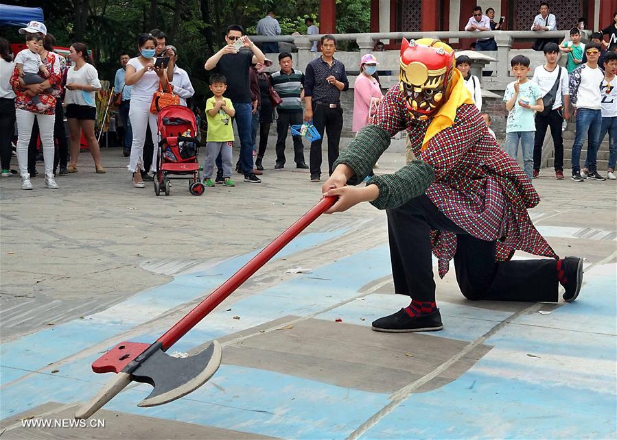 Tourists view Nuo dance at China's Yongcheng