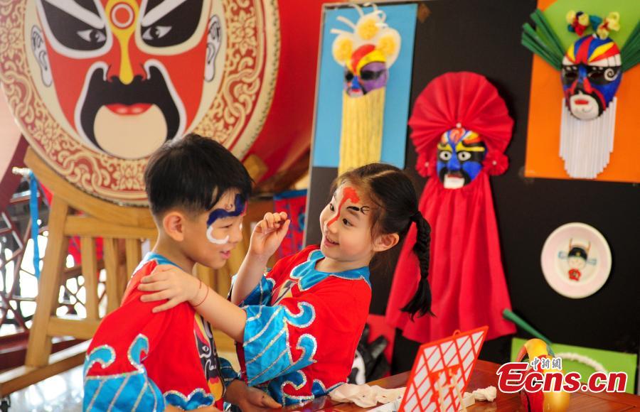 Children in traditional clothes experience classic Chinese culture