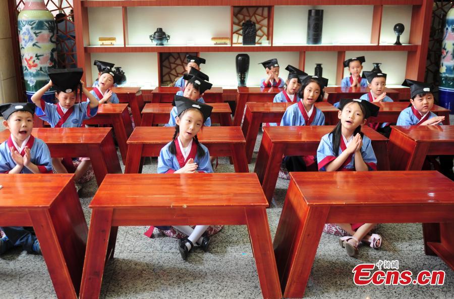 Children in traditional clothes experience classic Chinese culture