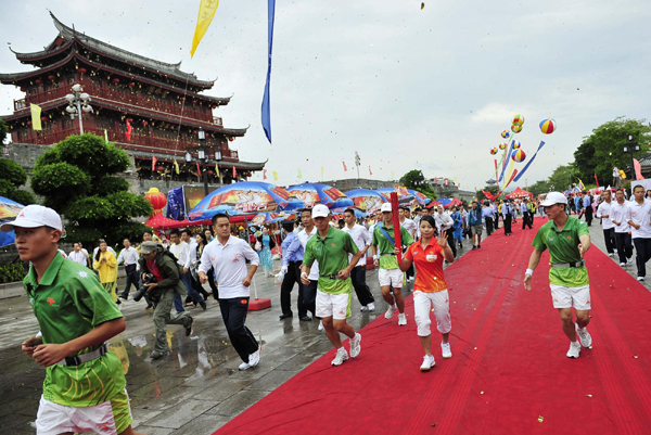 火炬首次雨中传递 “鲇鱼”挡不住圣火侨乡之旅