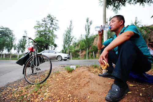 中国面孔：乡村路上快乐的绿色自行车