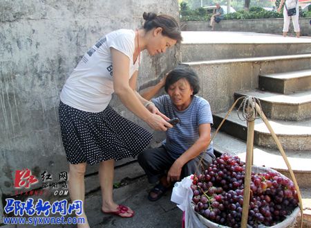 六旬水果摊贩意外摔伤 市民城管出手相助