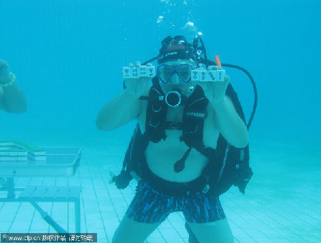 Divers play mahjong underwater to avoid the scorching weather in Xiangtan, Hunan province