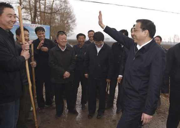 李克强雨中翻地看墒情