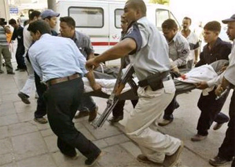 A wounded Iraqi policeman is rushed to a hospital following a car bomb explosion near a police station at Rashid street in central Baghdad, September 17, 2004. [Reuters]