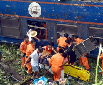 Philippine Air Force rescuers retrieve victims of a government owned Philippine National Railways train which fell into a ravine after it was derailed November 12, 2004 in Padre Burgos town in Quezon province south of Manila. At least 10 people died and hundreds of passengers were injured in the accident. [Reuters]