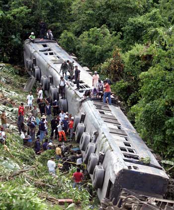 Rescuers search for victims of the government owned Philippine National Railways train which fell into a ravine after it was derailed November 12, 2004 in Padre Burgos town in Quezon province south of Manila. [Reuters]