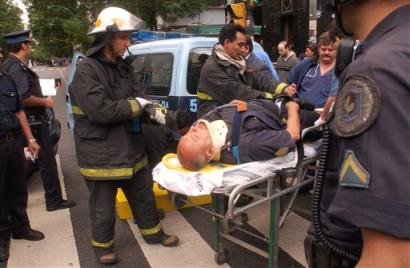 An injured policeman is assisted by firefighters and doctors following a homemade bomb blast at a bank in Buenos Aires, Argentina, Wednesday Nov.17, 2004. Bombs exploded in two Buenos Aires banks Wednesday, killing a security guard and shattering windows, police said. [AP]