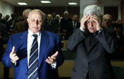 Palestinian Prime Minister Ahmed Qurie (L) and Palestine Liberation Organization chief Mahmoud Abbas pray at the beginning of a Palestinian parliament session in the West Bank city of Ramallah November 23, 2004. The dominant Palestinian political faction Fatah on Monday named Mahmoud Abbas as its candidate to succeed the late Yasser Arafat in a presidential election scheduled for January 9, 2005, officials said. [Reuters]