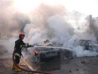 In this photograph released by the US Army, an Iraqi fireman extinguishes the flames from burning vehicles that were destroyed when a massive car bomb detonated on the Damascus Interchange near a checkpoint to Baghdads International Zone Saturday Dec. 4, 2004. No multinational forces were killed or injured in the blast but six Iraqi policemen were killed and 10 injured, officials said. (AP 