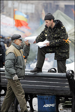 A supporter of Ukraine's pro-West opposition leader Viktor Yushchenko spreads leaflets at the tent camp in downtown Kiev. Ukraine's civil servants went back to work for the first time in weeks Thursday as the opposition lifted its blockade of government buildings and a tense political crisis eased following a compromise with the ruling regime.[AFP]