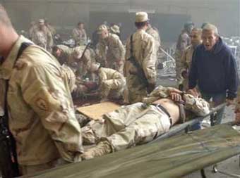 Workers and U.S. soldiers tend to the wounded after an apparent insurgent mortar attack on a dining facility during lunchtime on FOB Marez in Mosul, Iraq on Tuesday, Dec. 21, 2004. [AP]