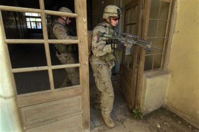 U.S. Army 1st Battalion, 24th Infantry soldiers raid a vacant hotel in Mosul, Iraq, Sunday, Jan. 16, 2005, after a report of insurgent sniper fire in the area. The Mosul area has emerged as a major flashpoint between U.S. and Iraqi forces and the insurgents, raising fears that the upcoming election cannot be held in much of the city, Iraq's third largest. [AP]