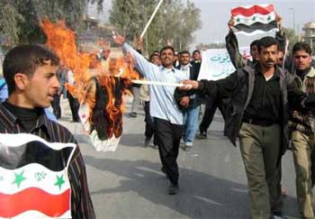 Iraqi policemen burn election posters of Interim Prime Minister Allawi, as they rally through the streets of Najaf, some 160 kilometers (100 miles) south of Baghdad, Monday, Jan. 17, 2005. Policemen demanded their salaries for last several months. (AP 