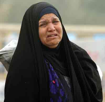 An Iraqi woman weeps at the scene of a car bomb attack in Baghdad January 18, 2005. The suicide car bomb exploded on Tuesday at a Baghdad office of the Supreme Council for the Islamic Revolution in Iraq (SCIRI), a party official said, in the latest attack on Shi'ites before Iraq's January 30 election. The official said there was no immediate word on casualties. [Reuters]