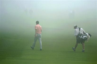 Charles Howell III and his caddy head back to the clubhouse at Torrey Pines after fog stopped play during the second round of the Buick Invitational Friday Jan. 21, 2005 in San Diego. [AP]