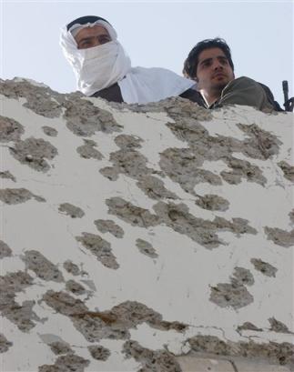 Kuwaiti State Security policemen look from the roof of the house in which Amer Khlaif al-Enezi was detained in Mubarak Al Kebir, south of Kuwait City on Monday, Jan. 31, 2005. [AP]