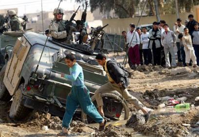 Scouts from the U.S. Army 1st Battalion 161st Regiment Washington State National Guard wait to be towed after they sank into an open sewer in the street while patroling an impoverished neighborhood in southern Baghdad, Iraq (news - web sites) Wednesday, Feb. 2, 2005. (AP Photo/John Moore) 