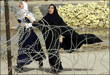 Women related to four Iraqi soldiers killed by a booby-trapped motorcycle run crying outside Basra hospital. The attack took place behind the general hospital in the Hay al-Rissala neighborhood. [AFP]