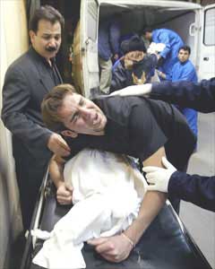 A man cries over the body of a relative who was killed in a mosque when a fire broke out at the Sina hospital in Tehran, Iran, Monday. (AP 