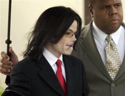 Entertainer Michael Jackson is escorted by an unidentified security guard, right, following his fifth day of his child molestation trial at the Santa Barbara County Superior Court Friday, March 4, 2005, in Santa Maria, Calif. [AP]