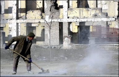 An Afghan worker sweeps a road in front of shelled buildings in Kabul. A British man working as an advisor to the Afghan government has been shot dead in a drive-by attack in the embassy district of the capital Kabul(AFP/File/Shah Marai) 