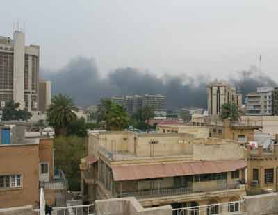 A pall of black smoke rises over the Baghdad skyline following a suicide truck bombing early March 9, 2005. A suicide bomber driving a garbage truck blew himself up on Wednesday near a Baghdad hotel used by Iraqi police and their foreign instructors, police said, shaking buildings and sending thick black smoke into the sky. [Reuters]