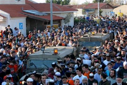 Jewish settlers gather around two army jeeps as the pray during a massive prayer held in front of the synagogue of the Jewish settlement of Neve Dekalim in the Gush Katif bloc of settlements in Gaza Strip (news - web sites) Thursday March 17, 2005. The prayer was part of a demonstration against Israel's planned withdrawal from the Gaza Strip and part of the West Bank. (AP Photo/Tsafrir Abayov) 