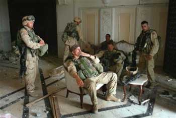 U.S. Army Stf. Sgt. Chad Touchett, center, relaxes with comrades from A Company, 3rd Battalion, 7th Infantry Regiment, following a search in one of Saddam Hussein's palaces damaged after a bombing, in Baghdad, in this April 7, 2003 file photo. [AP]