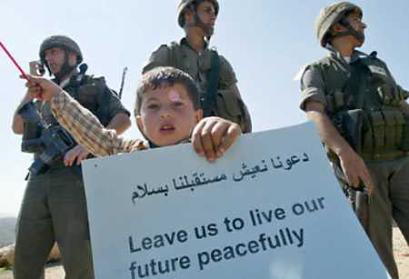 A Palestinian boy holds up a banner in front a group of Israeli border policemen during a protest against Israel's controversial barrier at the West Bank village of Bilin on March 20, 2005. Israel plans to hand over a second West Bank city to the Palestinians on Monday, Israel Radio said on Sunday, quoting Defense Minister Shaul Mofaz. Israeli security sources said Israeli and Palestinian officers would meet later on Sunday to finalize details of the troop pullback from Tulkarm. (Ammar Awad/Reuters) 