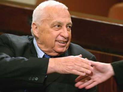 Israeli Prime Minister Ariel Sharon shakes hands with a Parliament member during a session of the Israeli Parliament in Jerusalem March 23, 2005. Sharon won a key vote over a state budget he must push through parliament by the end of the month or face a snap election that would threaten his plan to pull out of Gaza. [Reuters] 