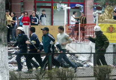 Law enforcement officers and opposition volunteers pursue looters at a shopping center on the main street, Beta Stores, in Bishkek, Kyrgyzstan, Friday, March 25, 2005. The opposition scrambled to restore law and order and fill the power vacuum Friday, a day after protesters drove Kyrgyz President Askar Akayev's government from power, unleashing widespread looting. (AP Photo/Vasily Shaposhnikov, Kommersant) 