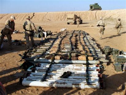 In this photo undated photo released by the U.S. Army Monday, March 28, 2005, U.S. Army Explosive Ordnance Disposal Team members from the 150th Engineer Battalion, 155th Brigade Combat Team prepare to destroy part of a large cache of weapons recovered recently near Forward Operating Base Dogwood, in Iraq. Iraq's outgoing interior minister predicted Monday his country's emerging police and army may be capable of securing the nation in 18 months, saying his officers are beginning to take over from coalition forces. [AP]