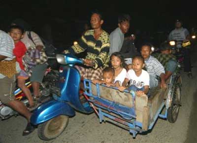 Acehnese cram onto a scooter and cart as they drive to higher ground following an earthquake, Tuesday, March 29, 2005, in Banda Aceh, Indonesia. A major earthquake struck off the west coast of Indonesia's Sumatra Island late Monday, and officials warned that a tsunami could strike the area. Residents of Banda Aceh fled their homes in panic. (AP 