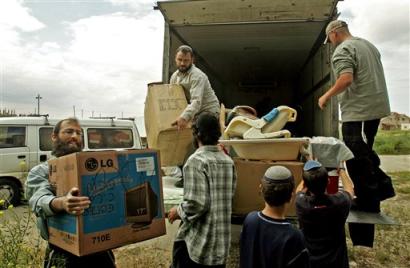 An Israeli settler family, name not given, coming from the West Bank, unload their belongings as they remove their house to the Jewish settlement of Kfar Darom in the Gush Katif block of settlements in the Gaza Strip Monday, April 4, 2005. The Jewish settlements in Gaza Strip are planned to be evacuated under the Israeli government's disengagement plan in the summer. (AP Photo/Baz Ratner) 