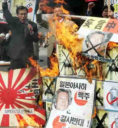 South Korean demonstrators burn anti-Japan banners at a rally in Seoul April 4, 2005. Protesters criticised on Monday a new controversial Japanese history textbook about Japan's military aggression in Asia and its 1910-1945 colonial rule over the Korean Peninsula, and demanded the boycott of Japanese products in the local market. The slogan in the front banner reads "Boycott of Japanese Asahi beer and Japanese products." [Reuters]