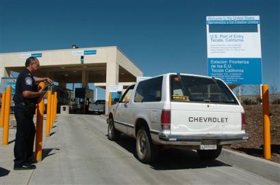 A U.S. Customs and Border Protection officer observes cars entering the new port of entry border crossing in Tecate, Mexico in this March 11, 2005 photo. In addition to increased personnel and other security measures, border crossings now include radiation detectors for automobiles and cargo trucks. As the Presidents of the U.S., Mexico and Canada meet in Texas on Wednesday March 23, a tighter cooperation between the three governments over security issues will be in the agenda. (AP Photo/David Maung) 