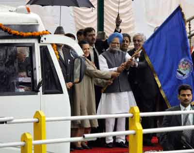 India's Prime Minister Manmohan Singh (C) flags off the historic first bus to Muzaffarabad, capital of Pakistan administered Kashmir, in Srinagar April 7, 2005. Buses set off from the capitals of Indian and Pakistani Kashmir on Thursday, carrying passengers bound for the other side of the divided territory for first time in nearly 60 years, in a major boost for the peace process between the nuclear rivals. [Reuters]