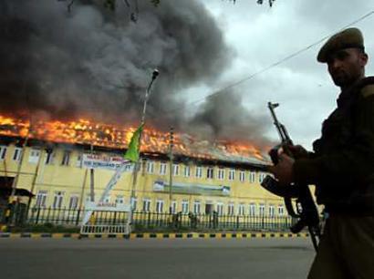 An Indian soldier runs past a burning government building after an attack in Srinagar, April 6, 20005. Gun-toting Islamic rebels on Wednesday stormed and torched the center sheltering passengers due to travel on a historic bus ride between divided Indian and Pakistani Kashmir, causing dozens of injuries. (Desmond Boylan/Reuters) 